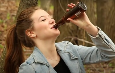 Девушка пьет пиво из бутылки
